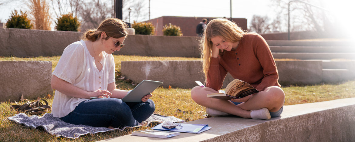 Two students studying outside on the Peace Mall